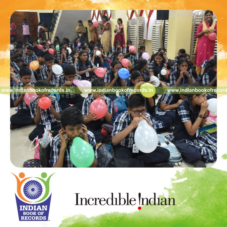Participants blowing and popping balloons together at one venue for a record in the Indian Book of Records