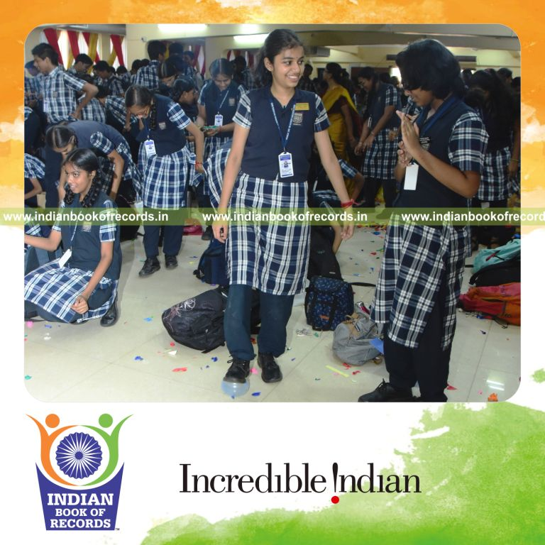 Participants popping balloons using their feet simultaneously at a single venue for the Indian Book of Records