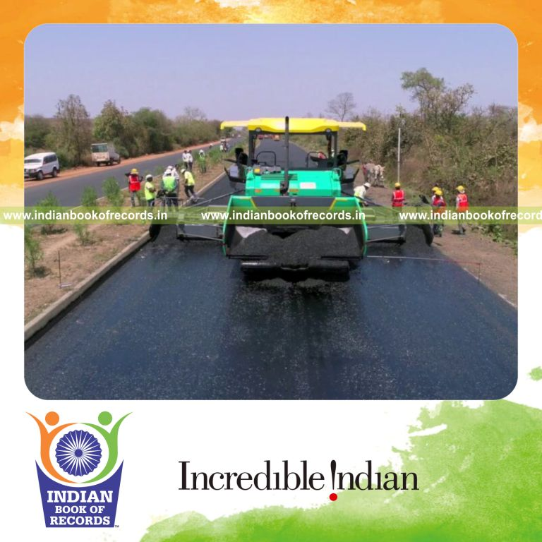 Road construction team laying bituminous concrete over a record distance, recognized by Indian Book of Records.