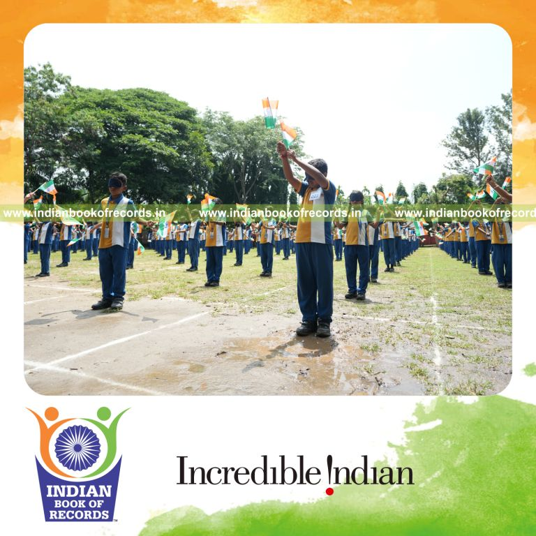 Participants performing a sports drill blindfolded while holding the national flag at a single venue for the Indian Book of Records