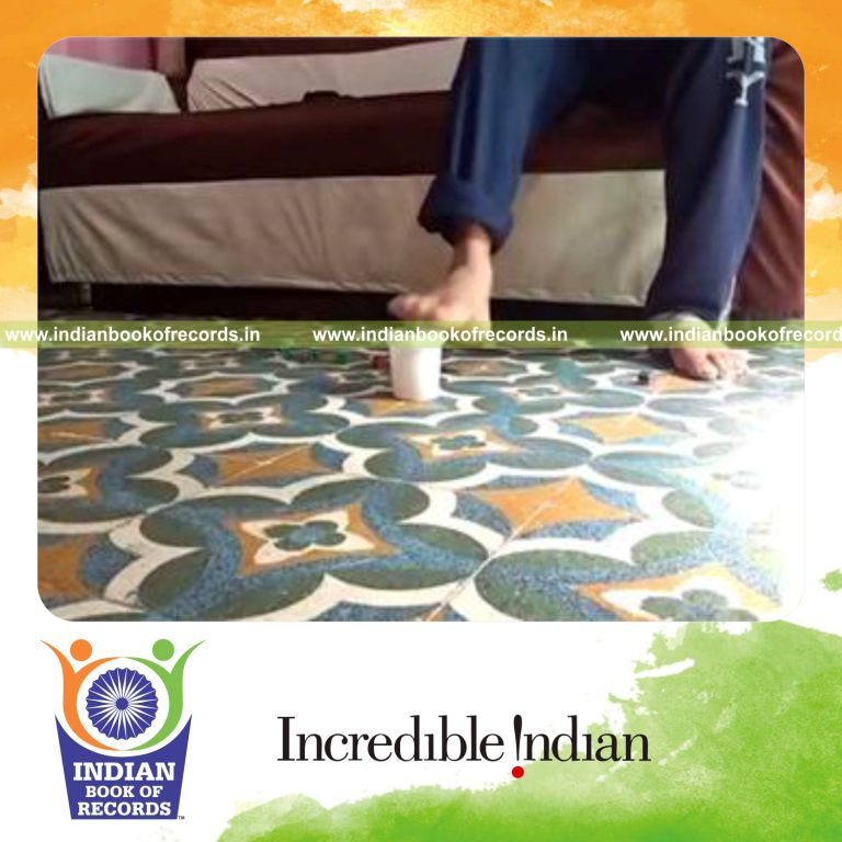 individual picking up 10 dice using foot and placing in cup in fastest time for record in Indian Book of Records