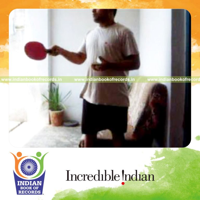 individual performing thumb card cuts while bouncing ball on alternate sides of paddle for record in an Indian Book of Records