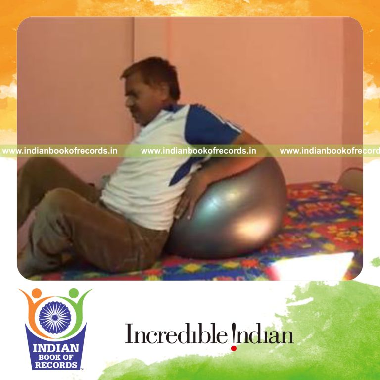 individual performing 100 head dips lying on exercise ball for record in Indian Book of Records