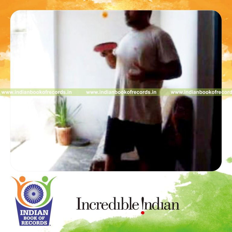 individual performing thumb card cuts while bouncing ball on alternate sides of paddle for record in Indian Book of Records