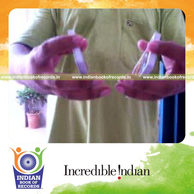 individual performing two handed sabers flipper card cut behind the back for record in Indian Book of Records