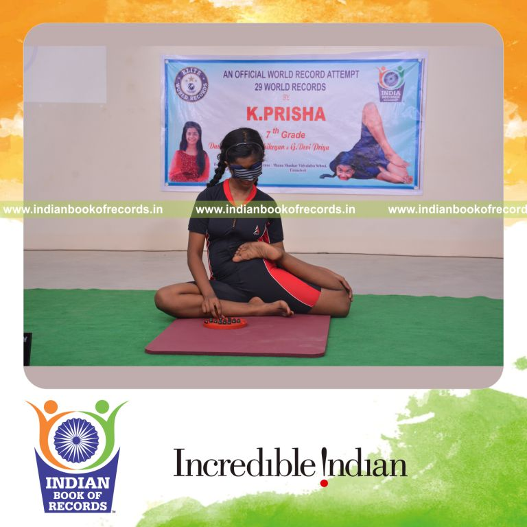 individual female solving brainvita while holding vamadevasana yoga pose blindfolded for Indian Book of Records