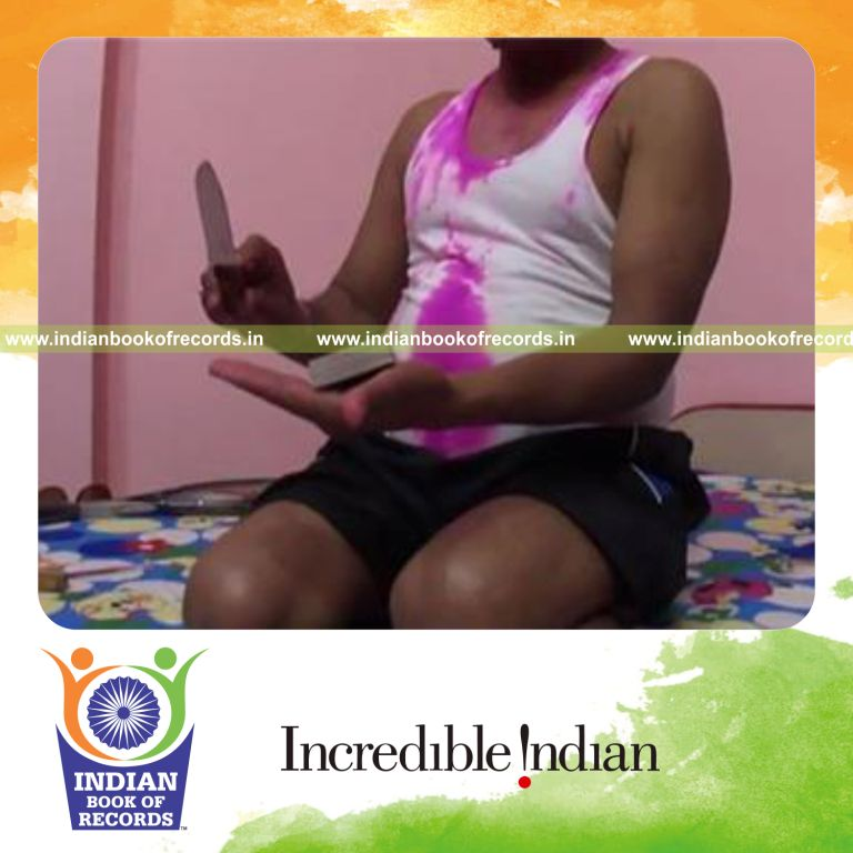 individual cutting deck of playing cards in hand using knife quickly for record in Indian Book of Records