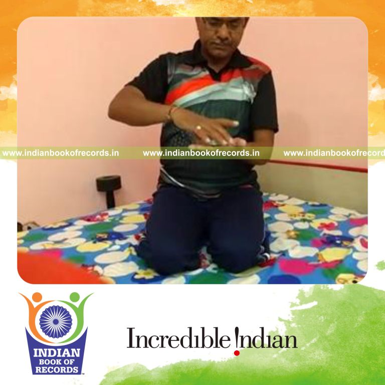 individual dealing cards with five coins stacked on deck quickly for record in Indian Book of Records