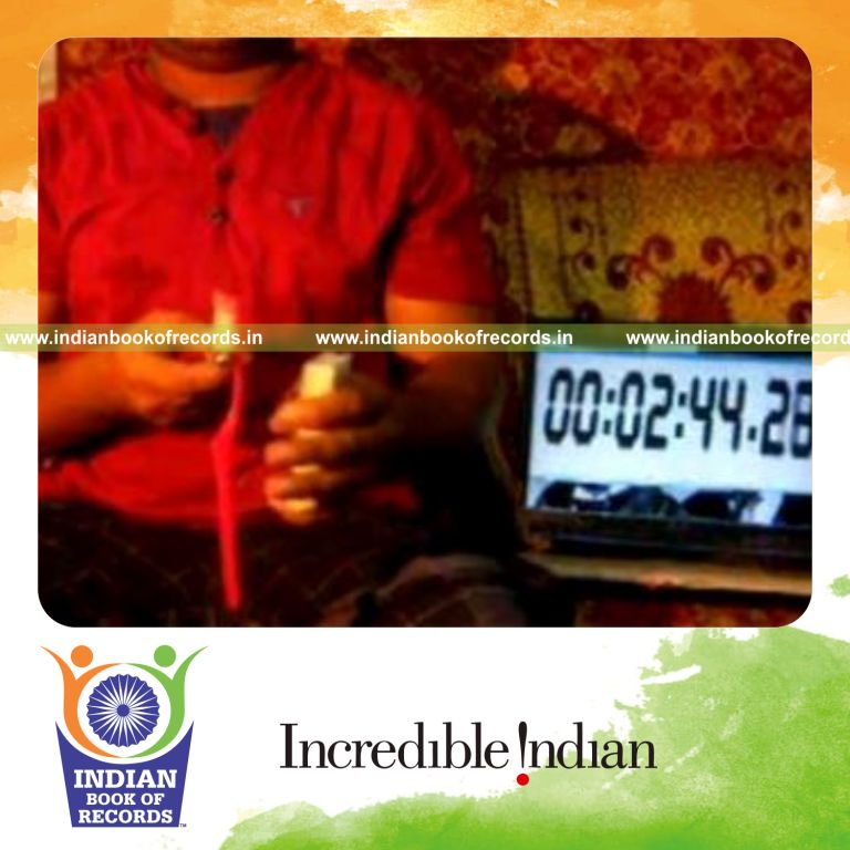 individual performing kryptonite triple card cut while spinning toothbrush on pen for record in Indian Book of Records