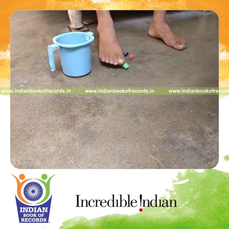individual picking up four dice using foot and placing in cup in fastest time for record in Indian Book of Records