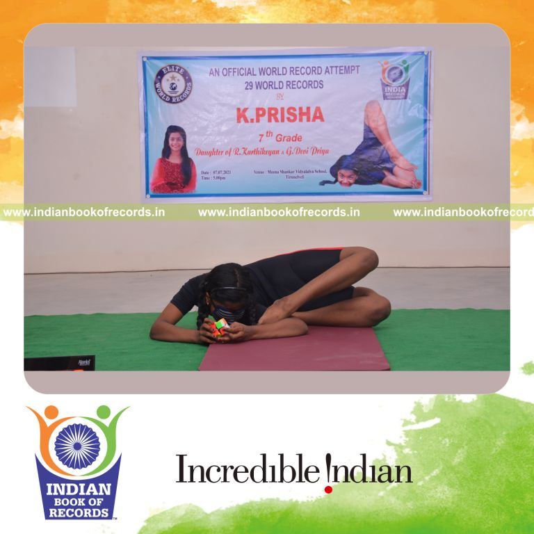 individual female solving 2x2 rubik cube while holding kapotasana yoga pose blindfolded for Indian Book of Records