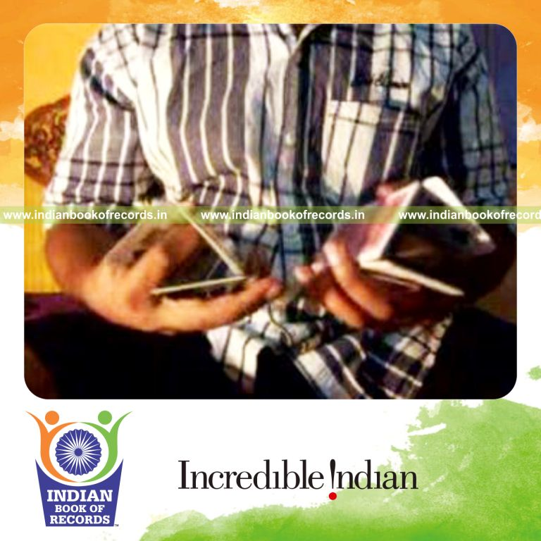 individual making triangle display in each hand using playing cards for record in Indian Book of Records