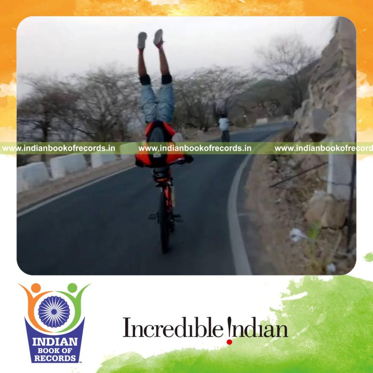 individual performing headstand while riding bicycle for Indian Book of Records