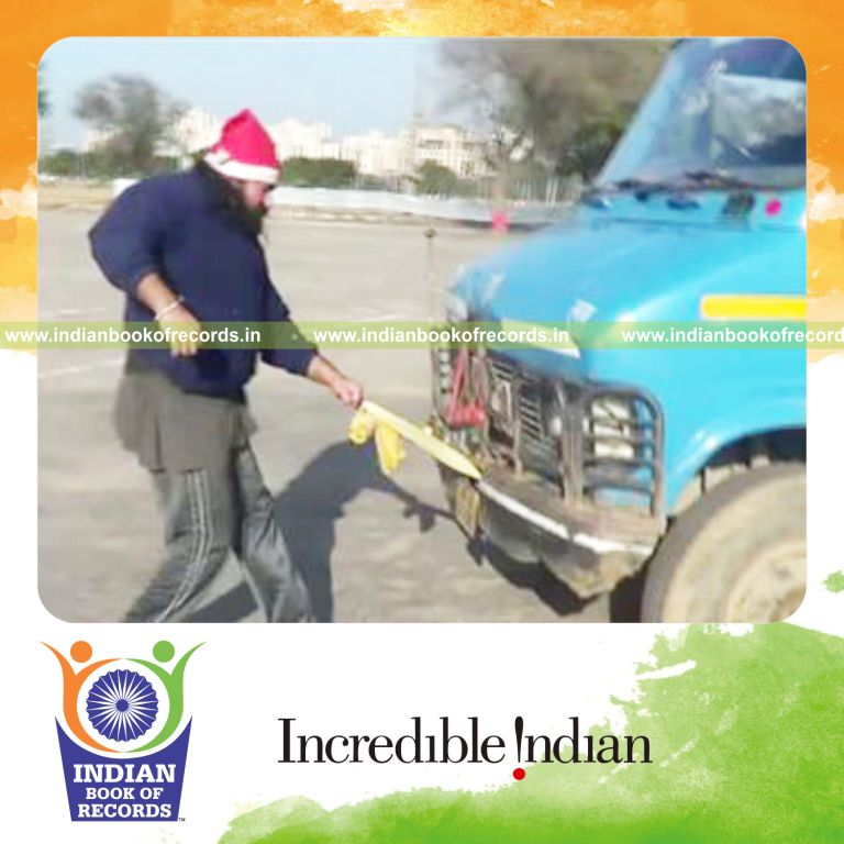 individual pulling heaviest vehicle with pinky finger for record in Indian Book of Records
