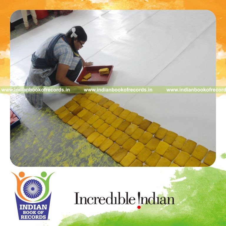 young female creating large mosaic using cookies for record in Indian Book of Records