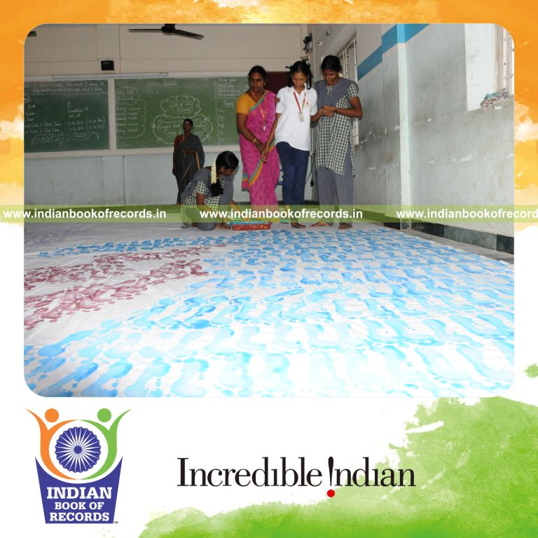 young female creating large footprint painting for record in Indian Book of Records