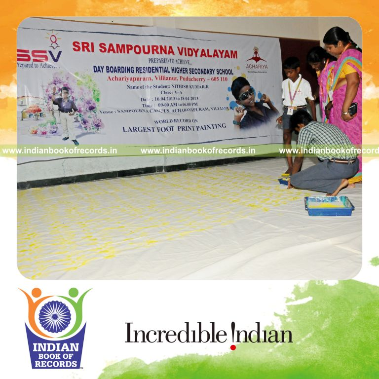 young male creating large footprint painting for record in Indian Book of Records