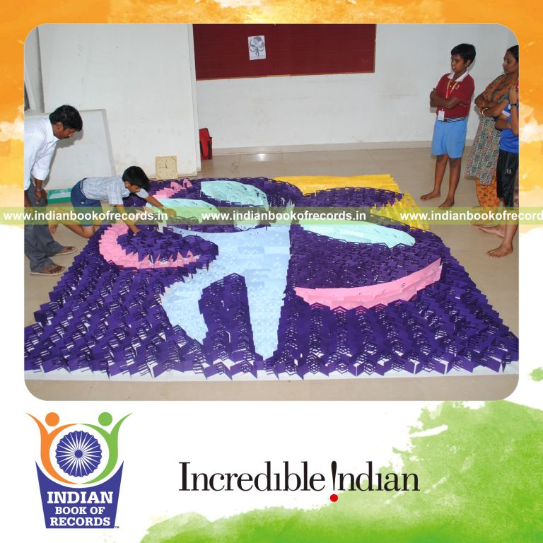 young male creating large kirigami mosaic artwork for record in Indian Book of Records