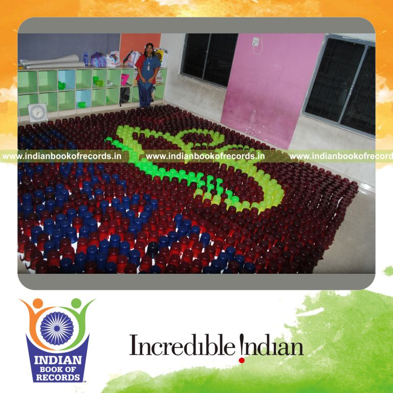 young female creating large mosaic using mugs for record in Indian Book of Records