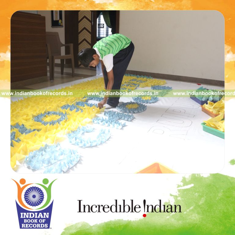 A large mosaic artwork created using numerous origami boats for Indian Book of Records recognition