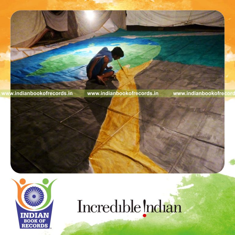 male artist creating large painting using mouth technique during Indian Book of Records attempt