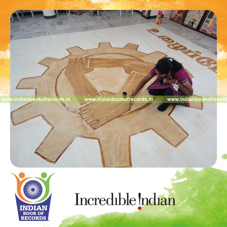 female individual creating large painting using coffee powder for record in Indian Book of Records