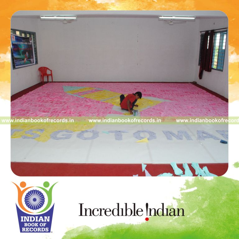 young male creating large mosaic using paper arrows for record in Indian Book of Records
