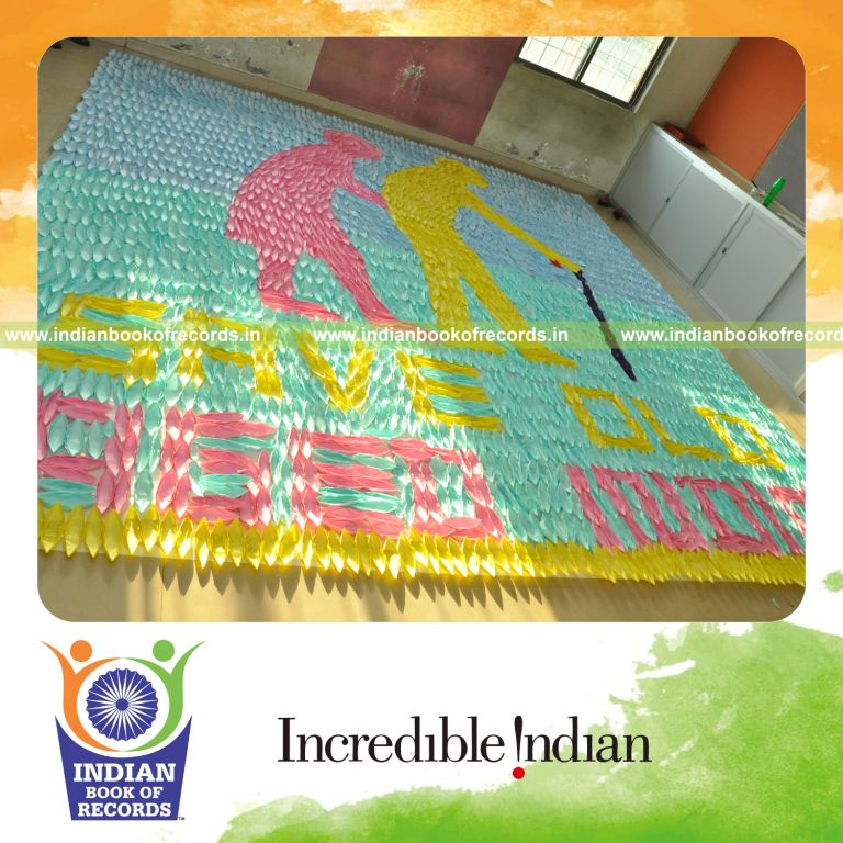 young male creating large mosaic using paper boats for record in Indian Book of Records