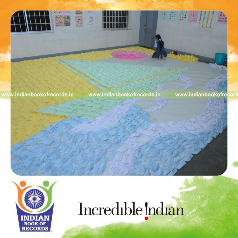 young girl creating mosaic using paper boats for Indian Book of Records