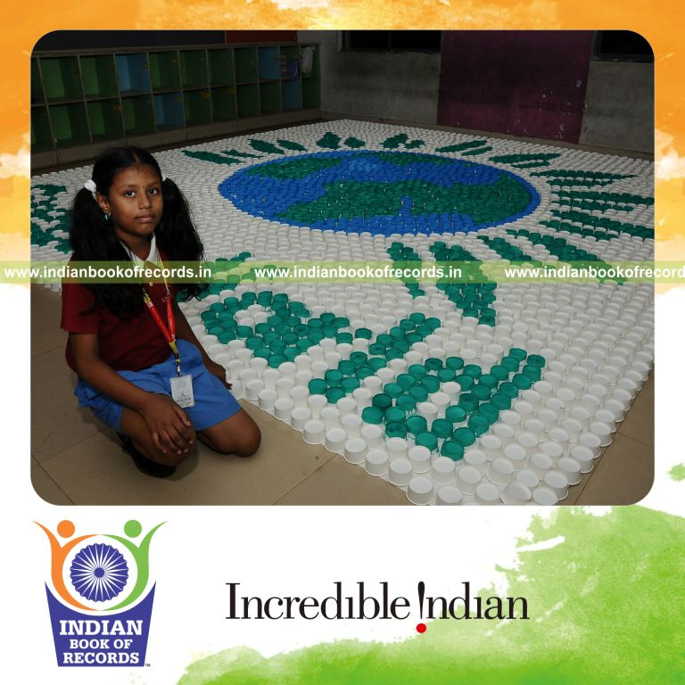young female creating large mosaic using paper cups for record in Indian Book of Records