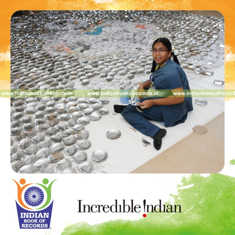 young female creating large mosaic using paper plates for record in Indian Book of Records
