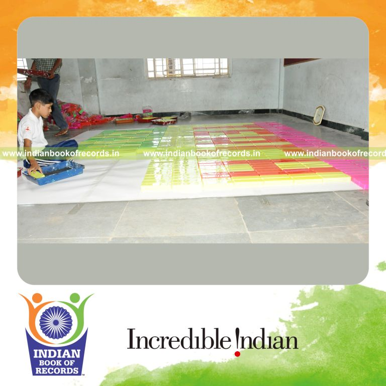 young male creating large mosaic using pencil boxes for record in Indian Book of Records