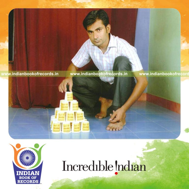 male individual creating pyramid using coffee cups for record in Indian Book of Records