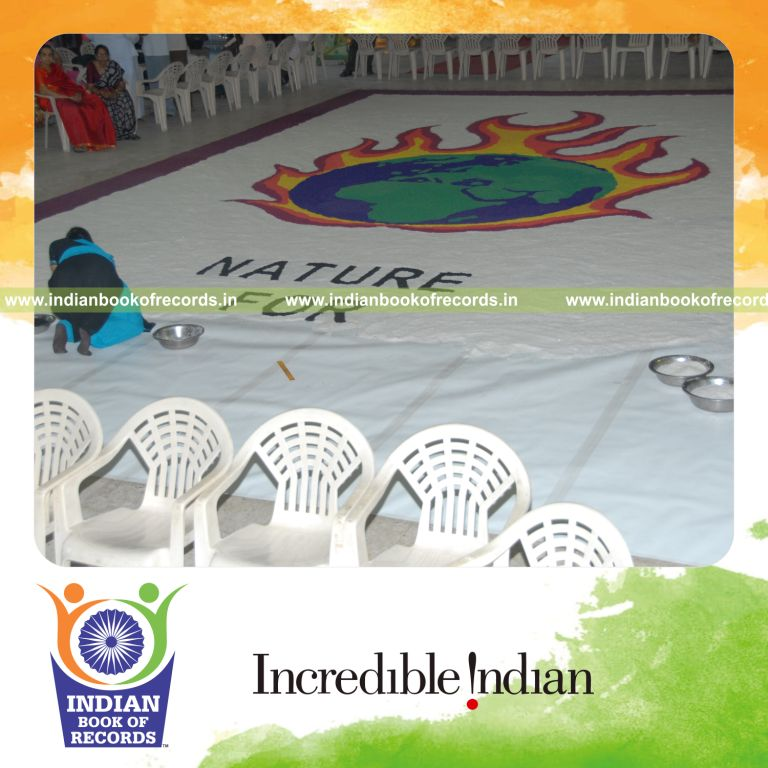 female individual creating large salt mosaic artwork for record in Indian Book of Records