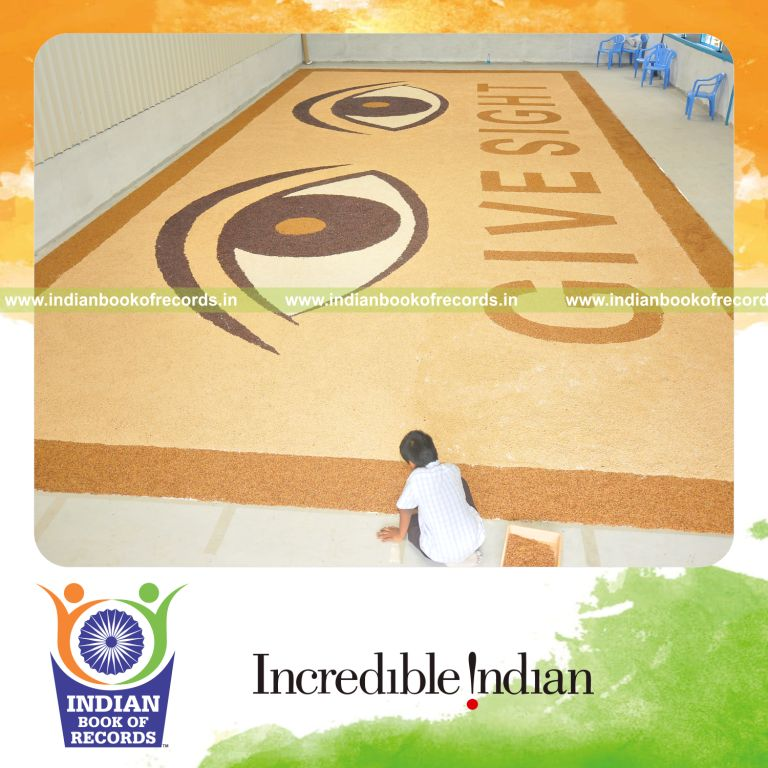 male individual creating large mosaic artwork using seeds for record in Indian Book of Records