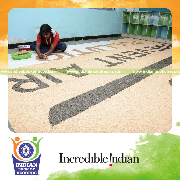 young female creating large mosaic using seeds for record in Indian Book of Records