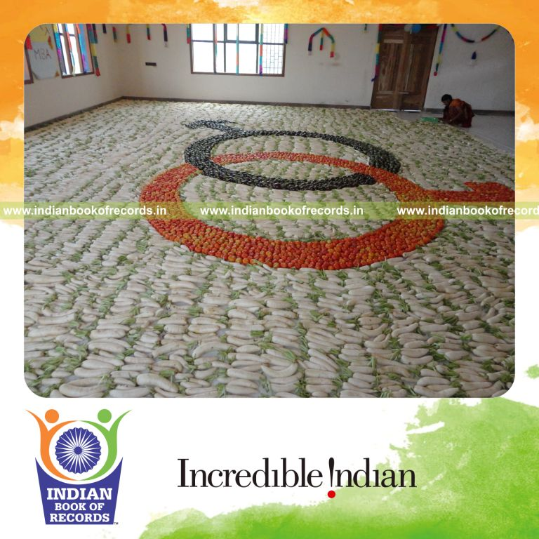 female individual creating large vegetable mosaic artwork for record in Indian Book of Records