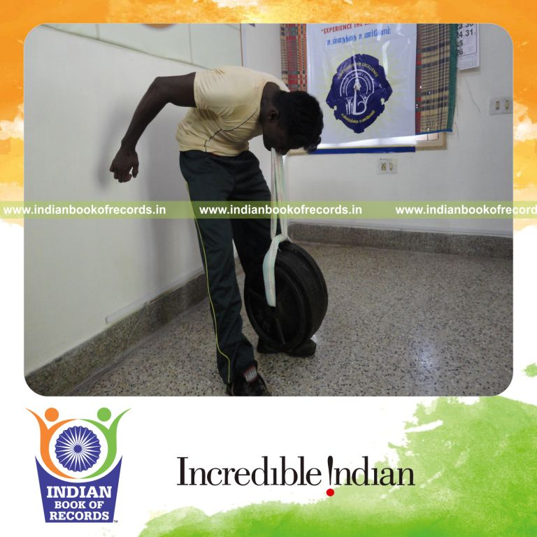 male individual lifting heavy weight using teeth for record in Indian Book of Records