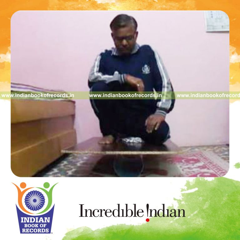 individual sitting on balance board holding vajra veerasana hero pose for record in Indian Book of Records