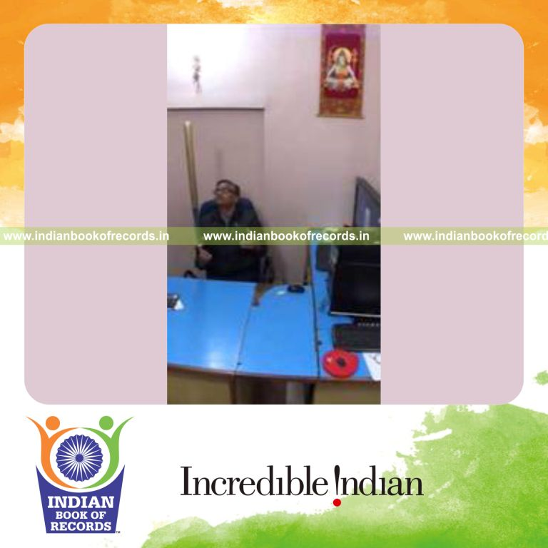 individual balancing baseball bat on thumb while holding thunderbolt pose on chair for record in Indian Book of Records