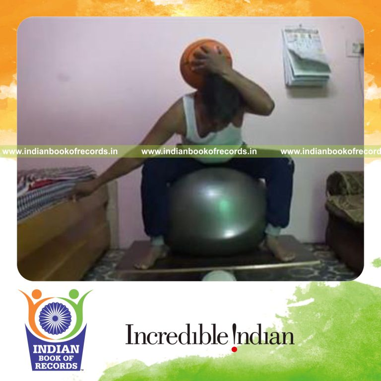 individual balancing basketball on neck while sitting on exercise ball on balance board for record in Indian Book of Records