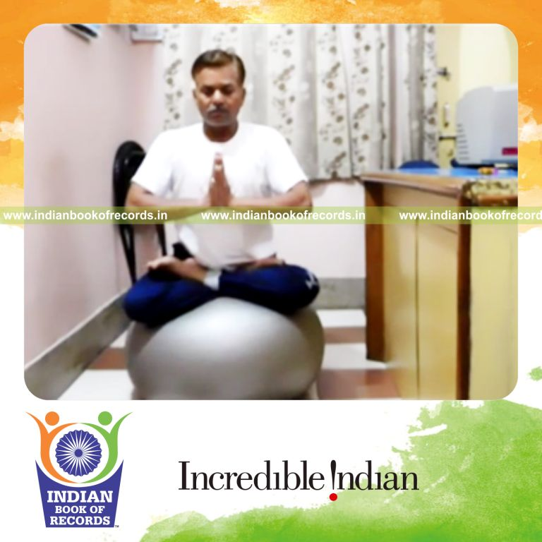 individual chanting om while holding lotus pose on yoga ball for record in Indian Book of Records