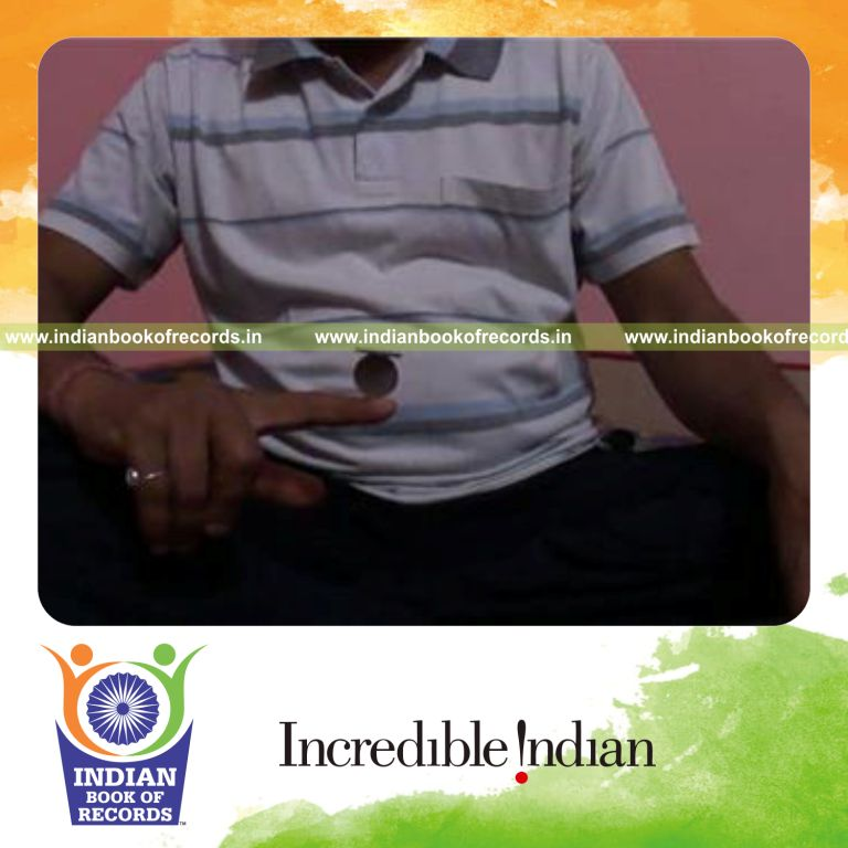 individual balancing coin on another coin on index finger for record in Indian Book of Records