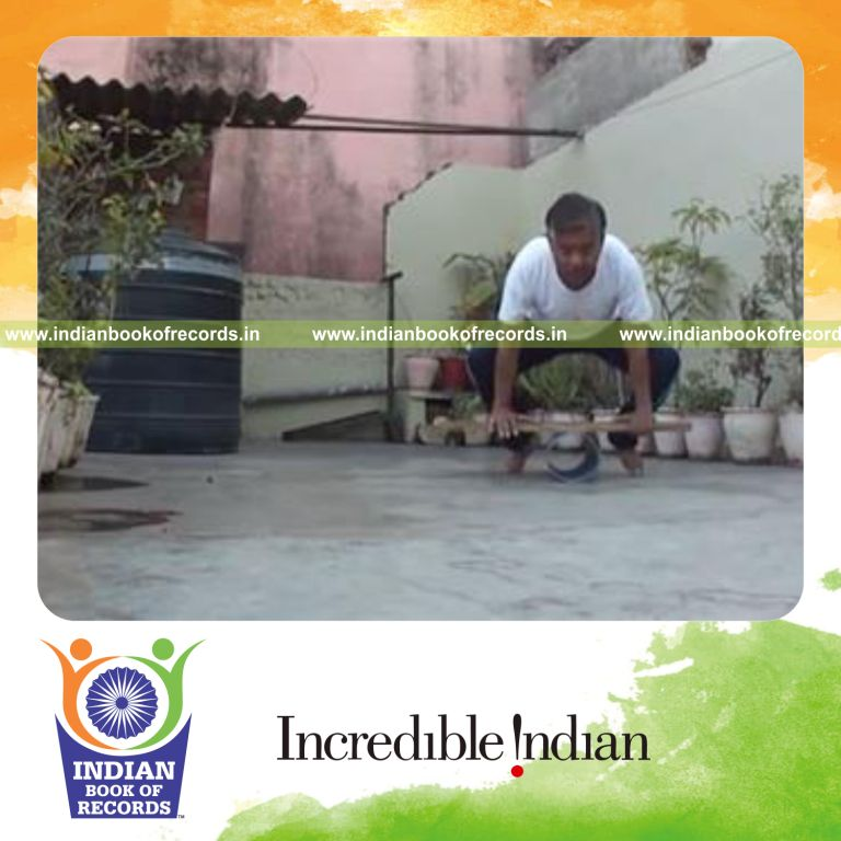 individual holding crow pose on balancing bar for record in Indian Book of Records