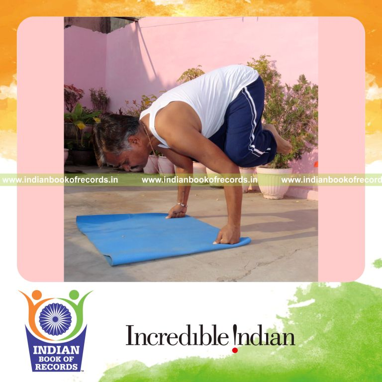 male holding crow yoga pose on fists for Indian Book of Records