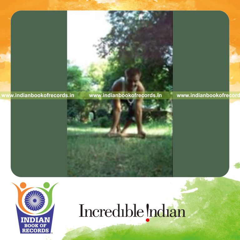 individual holding crow pose on pipe for record in Indian Book of Records