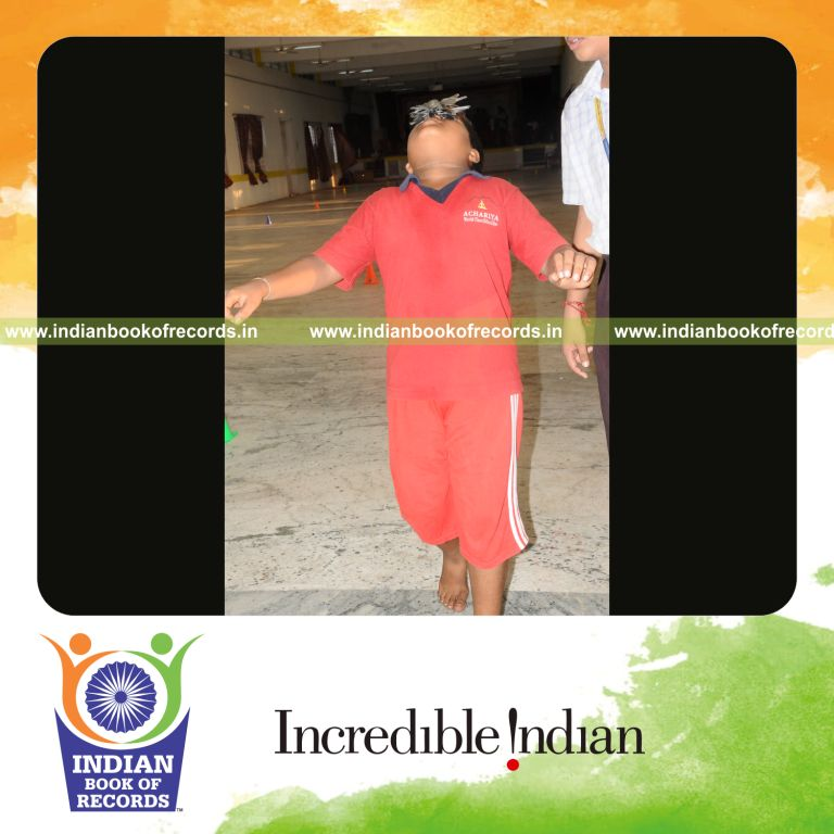 young male balancing multiple spoons on face while walking for record in Indian Book of Records