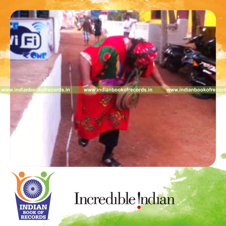 individual hopping backwards on one foot carrying 90kg in mouth for record in Indian Book of Records