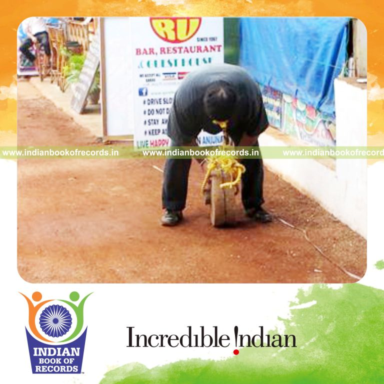 individual walking longest distance carrying 50kg weight attached to hair for record in Indian Book of Records