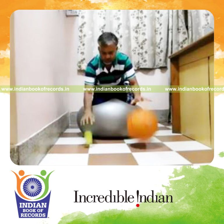 individual dribbling basketball and tennis ball simultaneously while kneeling on exercise ball for record in Indian Book of Records